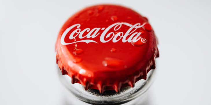 Kapsel butelki z logo marki Coca-Cola, będącym przykładem najlepszych projektów logo.