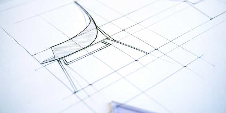 Eine zweidimensionale Zeichnung eines Stuhls liegt auf einem Tisch.