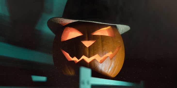 Een enge Halloweenpompoen met een hoed op.