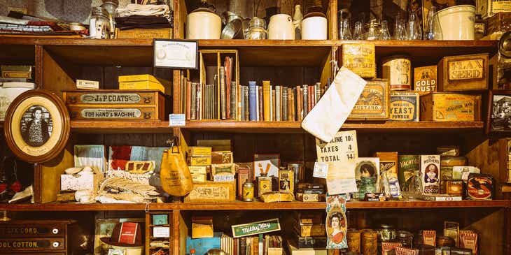 An assortment of old-fashioned items and trinkets on a wooden shelf.