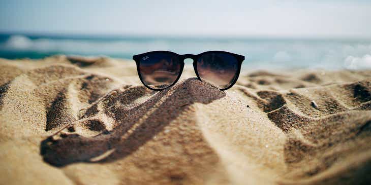 Okulary przeciwsłoneczne położone na piasku na plaży.