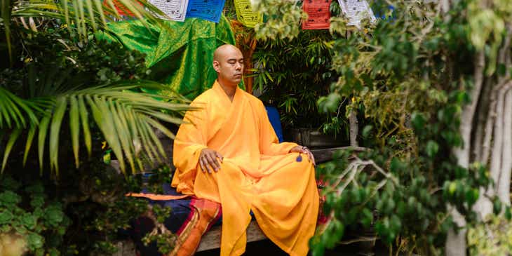Un moine zen en train de méditer dans un jardin.