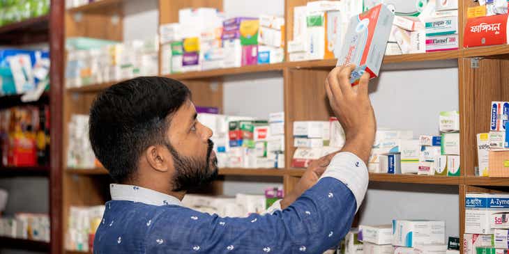 Ein Mann sortiert Medikamente in einer Apotheke.