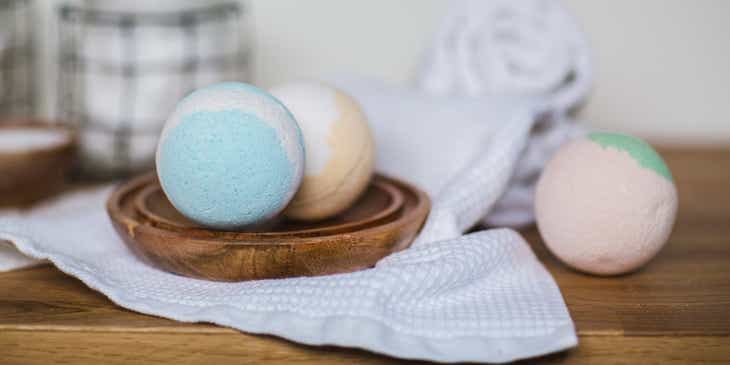Three bath bombs on a wooden table.