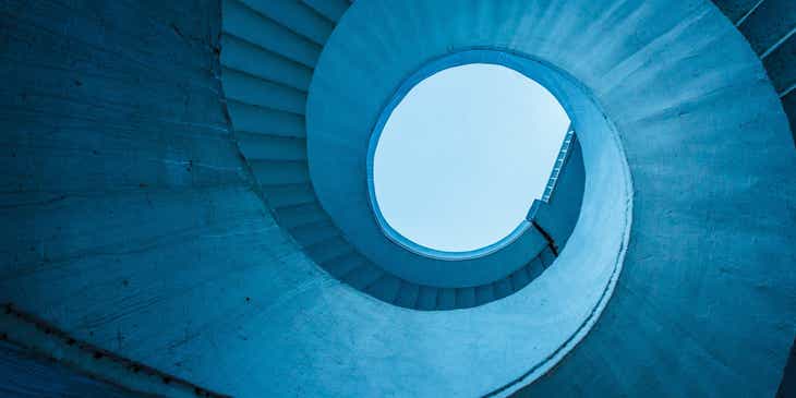 Una scala a spirale blu — o elicoidale — vista dal basso.