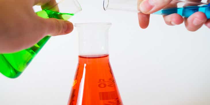 Rote, grüne und blaue Flüssigkeiten werden in einem Chemielabor vermischt.