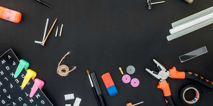 Tools for craft-making spread out over a black surface.