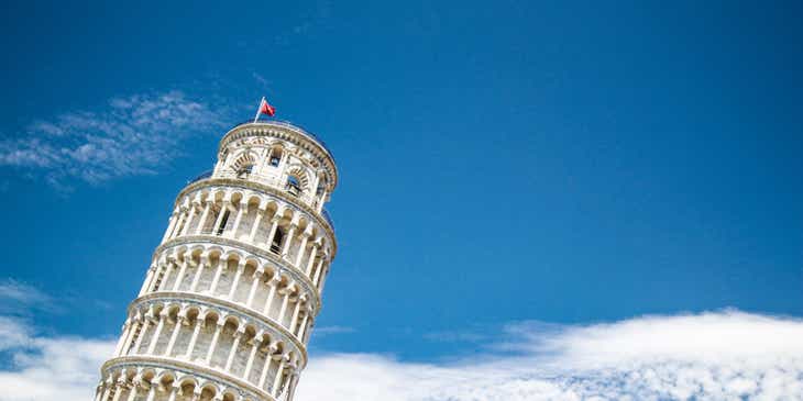Mavi gökyüzünün önünde eğimli Pisa Kulesi’nin bir fotoğrafı.