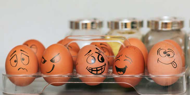 Eier, die mit lustigen Gesichtern dekoriert wurden, liegen in einer Küche auf einem Tisch.