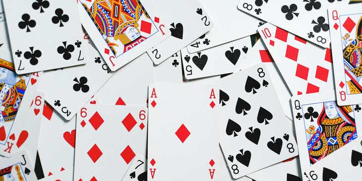 Muchos naipes desordenados sobre una mesa en un casino online.