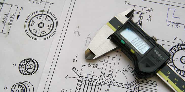 Ein Messgerät liegt auf einer technischen Skizze in einem Ingenieursbüro.