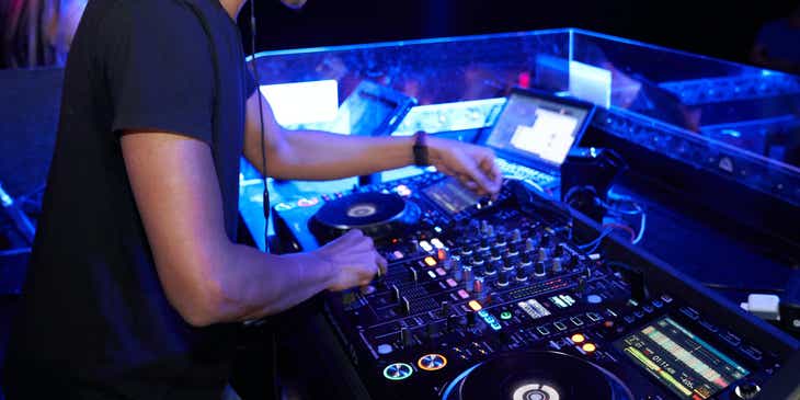 DJ grający w klubie, dostarczający rozrywkę imprezowiczom.