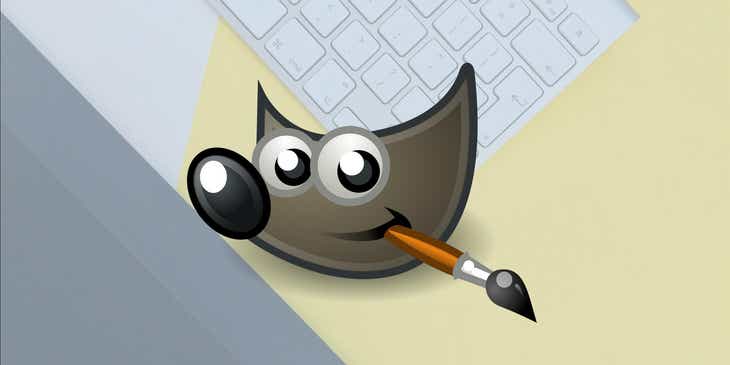 Logo GIMP na tle klawiatury i tabletu do rysowania.