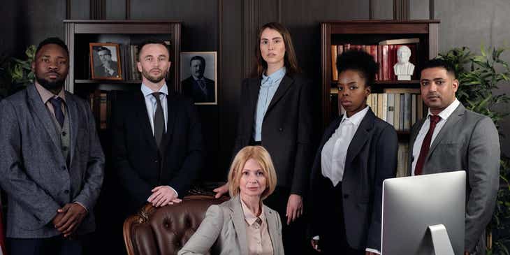 Een groep juristen poseren voor een foto op een advocatenkantoor.