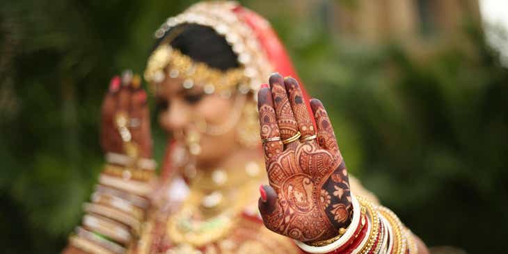 Seorang pengantin Hindu menunjukkan lukisan mandala di tangannya.