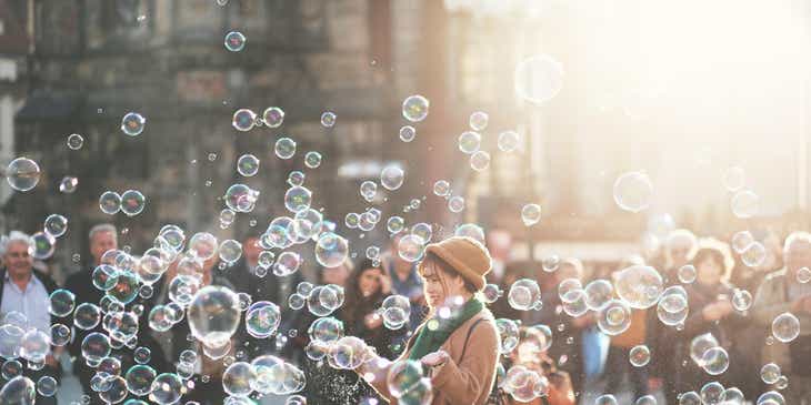 Una mujer jugando con burbujas de jabón en un logo divertido.