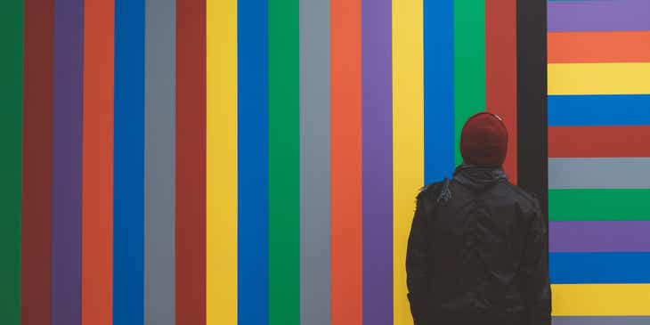 Una persona che guarda un murales colorato.