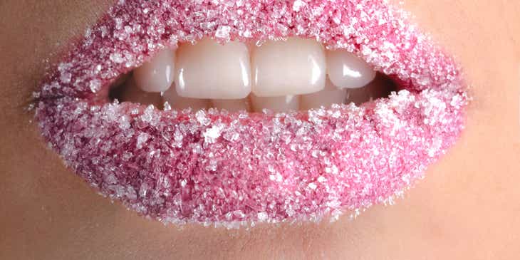 Mulut dengan lipstik pink dan taburan gula.