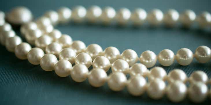 A string of pearls on a blue surface.