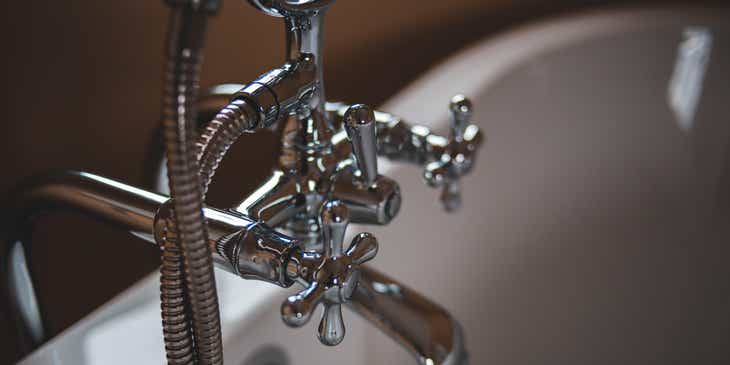 Plumbing work completed on a chrome bathtub faucet.