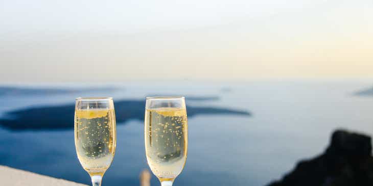 Due calici di champagne sul bordo di un balcone in un hotel raffinato con vista sul mare.