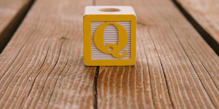 Drewniany klocek z literą „Q”.