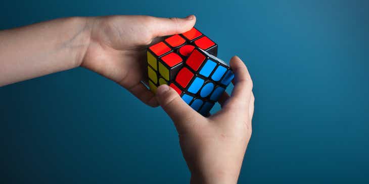 Bystra osoba rozwiązująca niebanalną układankę – Kostkę Rubika.