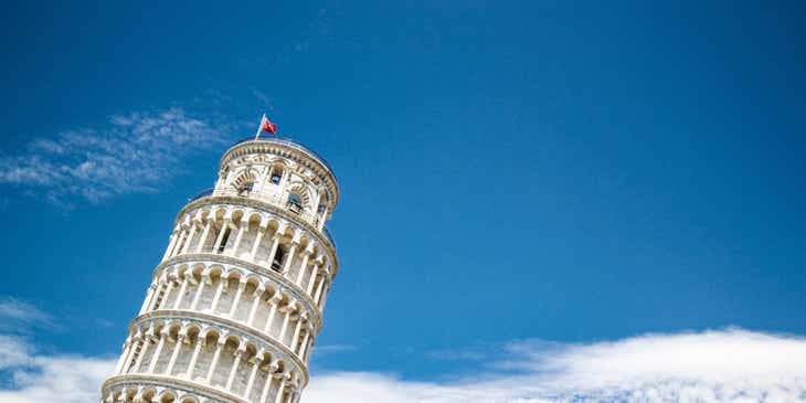 The tilted Leaning Tower of Pisa surrounded by blue sky.