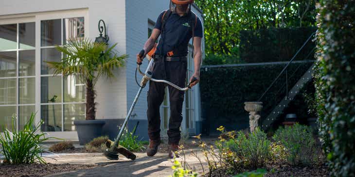 Een professional die aan het tuinieren is bij een klant.