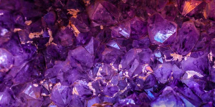 Bebatuan kristal dengan latar belakang ungu.