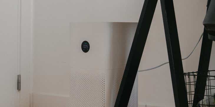 An air purifier placed next to a desk.