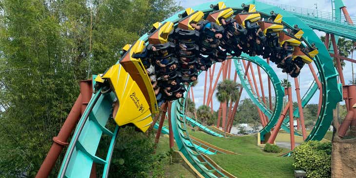 Orang-orang mengendarai roller coaster di taman hiburan.