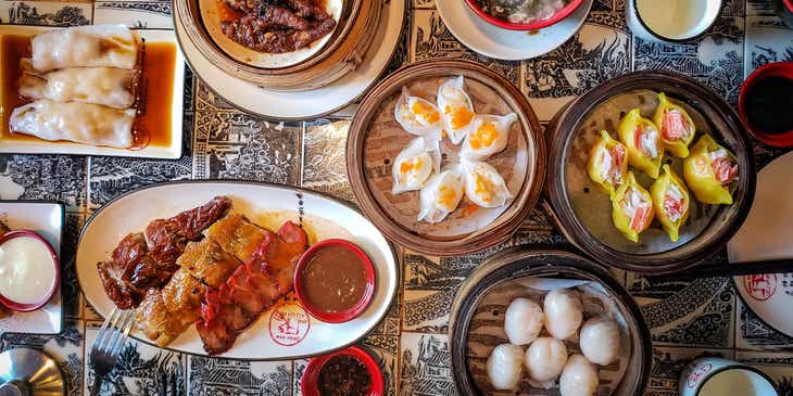Divers plats asiatiques servis dans des assiettes en céramique blanche dans un restaurant asiatique.