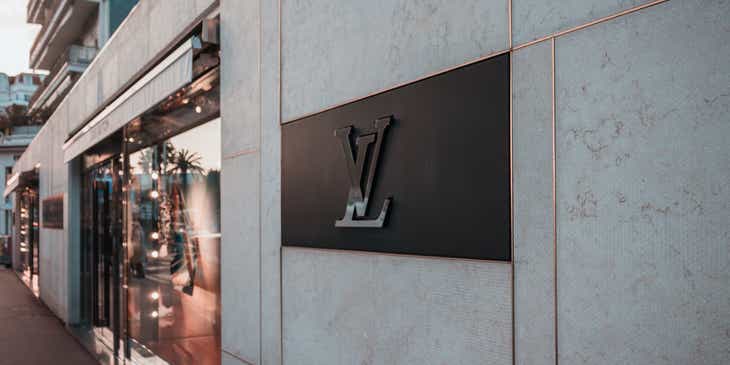 Cuplikan logo avant-garde merek Louis Vuitton di sisi sebuah bangunan.