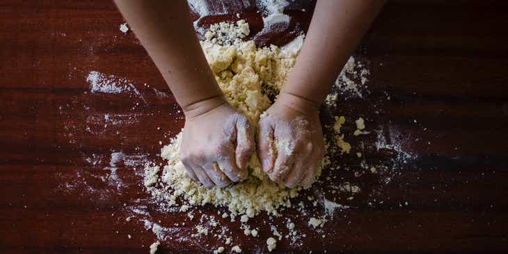 A baker kneeding dough for baked goods.