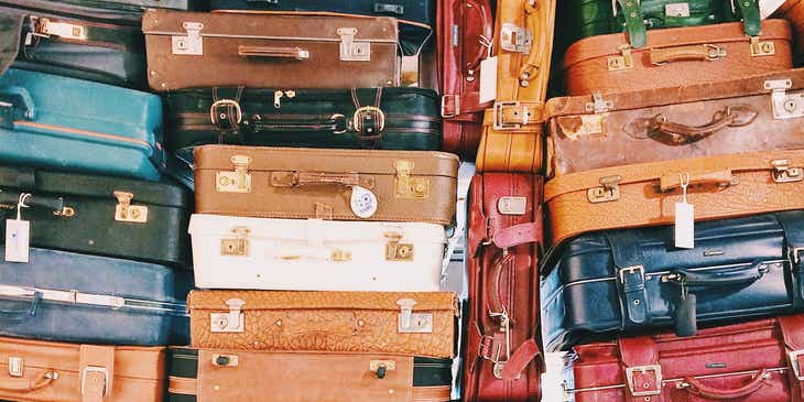 Un montón de maletas de diferentes colores y tamaños apiladas unas encima de otras.