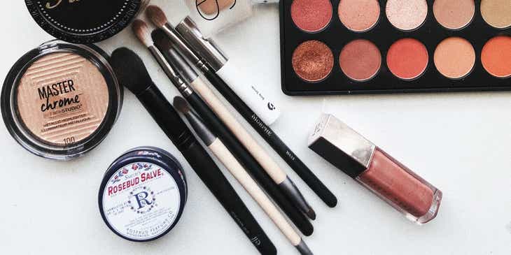 Lidschatten, Pinsel und andere Make-up-Produkte sind auf einer hellen Oberfläche in einem Schönheitssalon ausgebreitet.