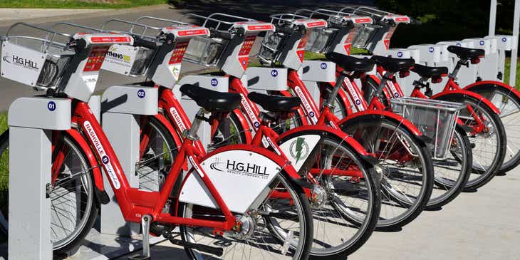 Rote Fahrräder sind in einer Reihe an einer automatischen Verleihstation geparkt.