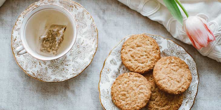Biscuits on a plate next to a tea cup.