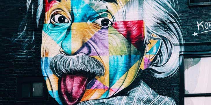 Une œuvre d'art osée peinte sur un mur, représentant la photo d'Einstein tirant la langue.