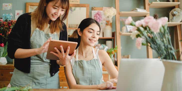 Dwie dziewczyny korzystające z urządzeń elektronicznych do prowadzenia swojego biznesu w sferze online.