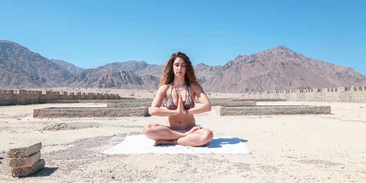 Sakinleştirici bir manzarada meditasyon yapan bir kadın.