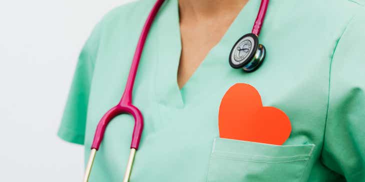 Seorang kardiolog mengalungkan stetoskop dengan hati merah di sakunya.