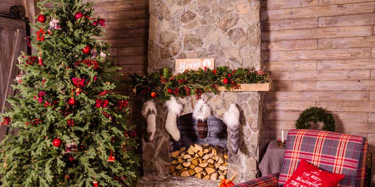 Een kerstboom met daaronder cadeautjes voor Kerstmis en een open haard met sokken.