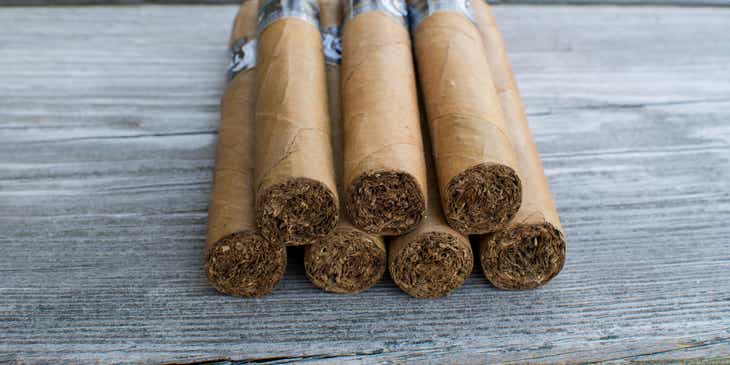 A stack of cigars displayed on a wooden surface.
