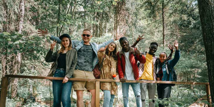 Grupa przyjaciół należących do klubu zainteresowań pozująca do zdjęcia w trakcie wycieczki do lasu.