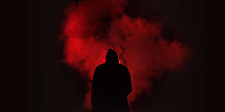 Un personnage rétro-éclairé par un éclairage rouge froid et une machine à fumée.