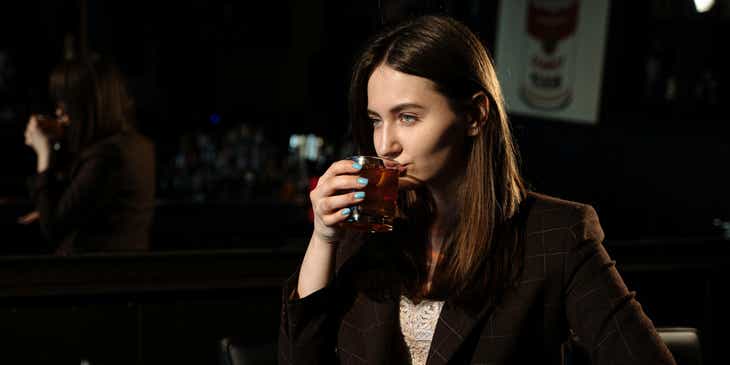Person drinking an alcoholic beverage.