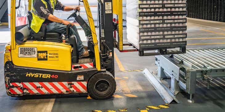 A person loading items using a forklift at a distribution company warehouse.
