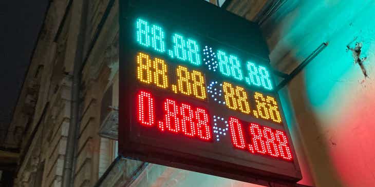 Een elektronisch uithangbord van een geldwisselkantoor met de wisselkoers van diverse valuta weergegeven in felle kleuren.